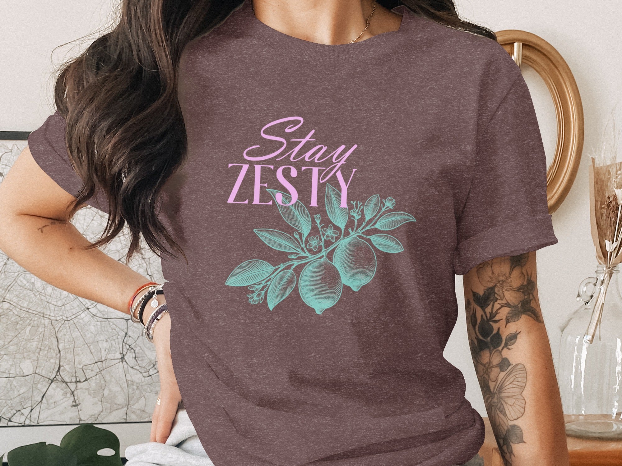 Brown t-shirt with pink text "Stay Zesty" and teal lemon branch graphic.