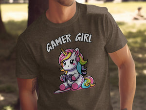 Brown t-shirt with a cartoon unicorn wearing headphones and holding a video game controller. Text reads "GAMER GIRL".