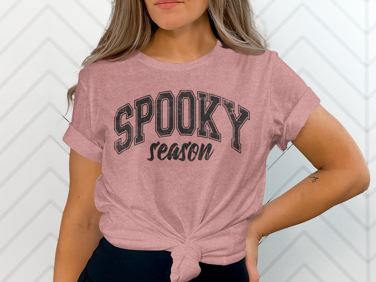 Pink t-shirt with black text "SPOOKY season" on a white background.