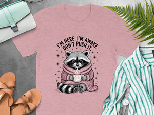 Pink t-shirt with raccoon graphic "I'm here, I'm awake, don't push it".
