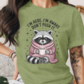 Green t-shirt with raccoon illustration and text "I'm here, I'm awake, don't push it."