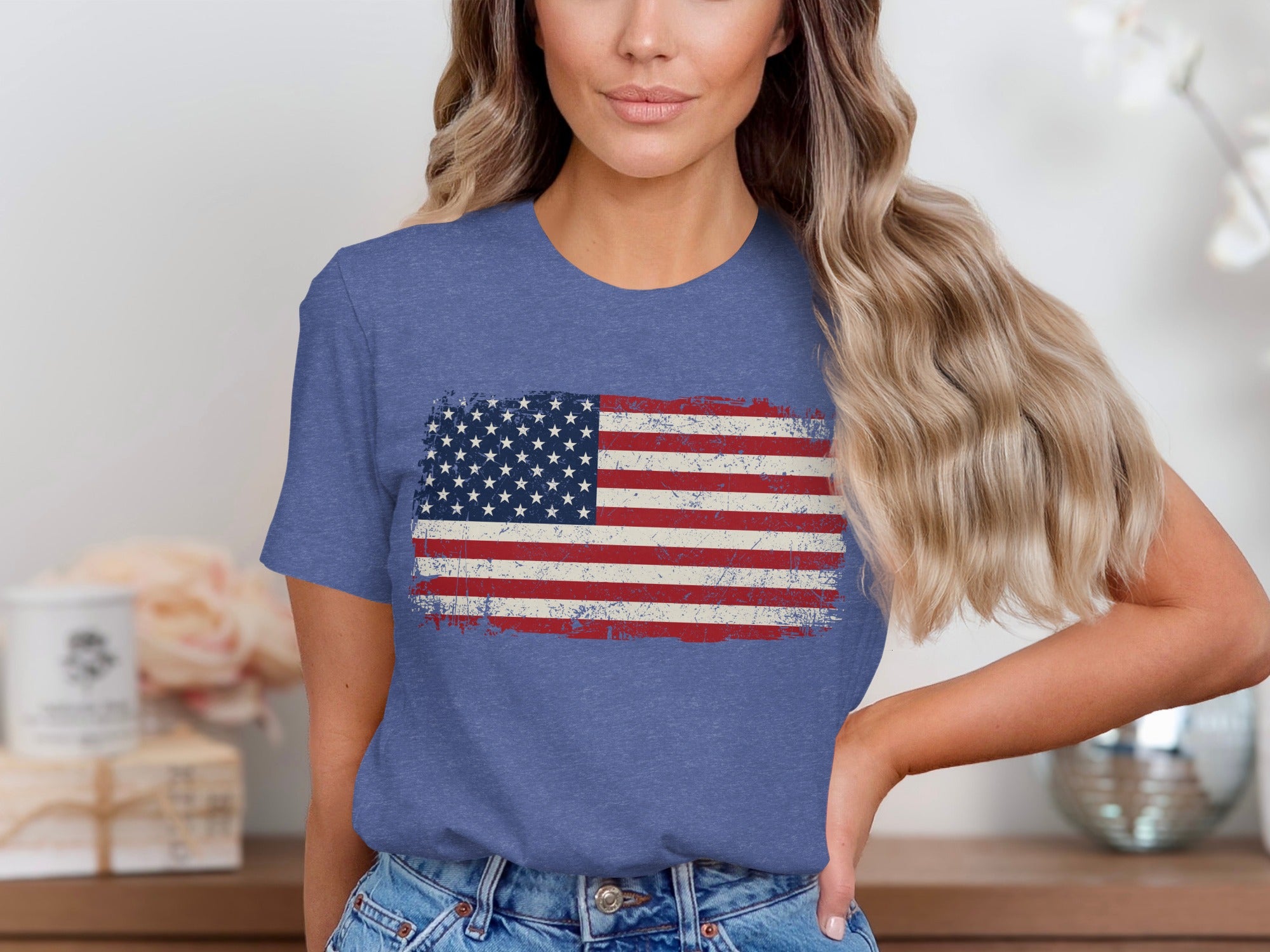 Distressed American flag graphic on a blue t-shirt worn by a woman.