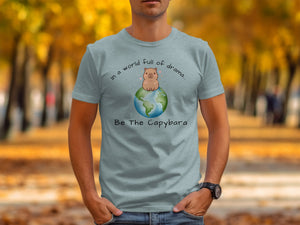 Light blue t-shirt with a cartoon capybara on Earth graphic and text.
