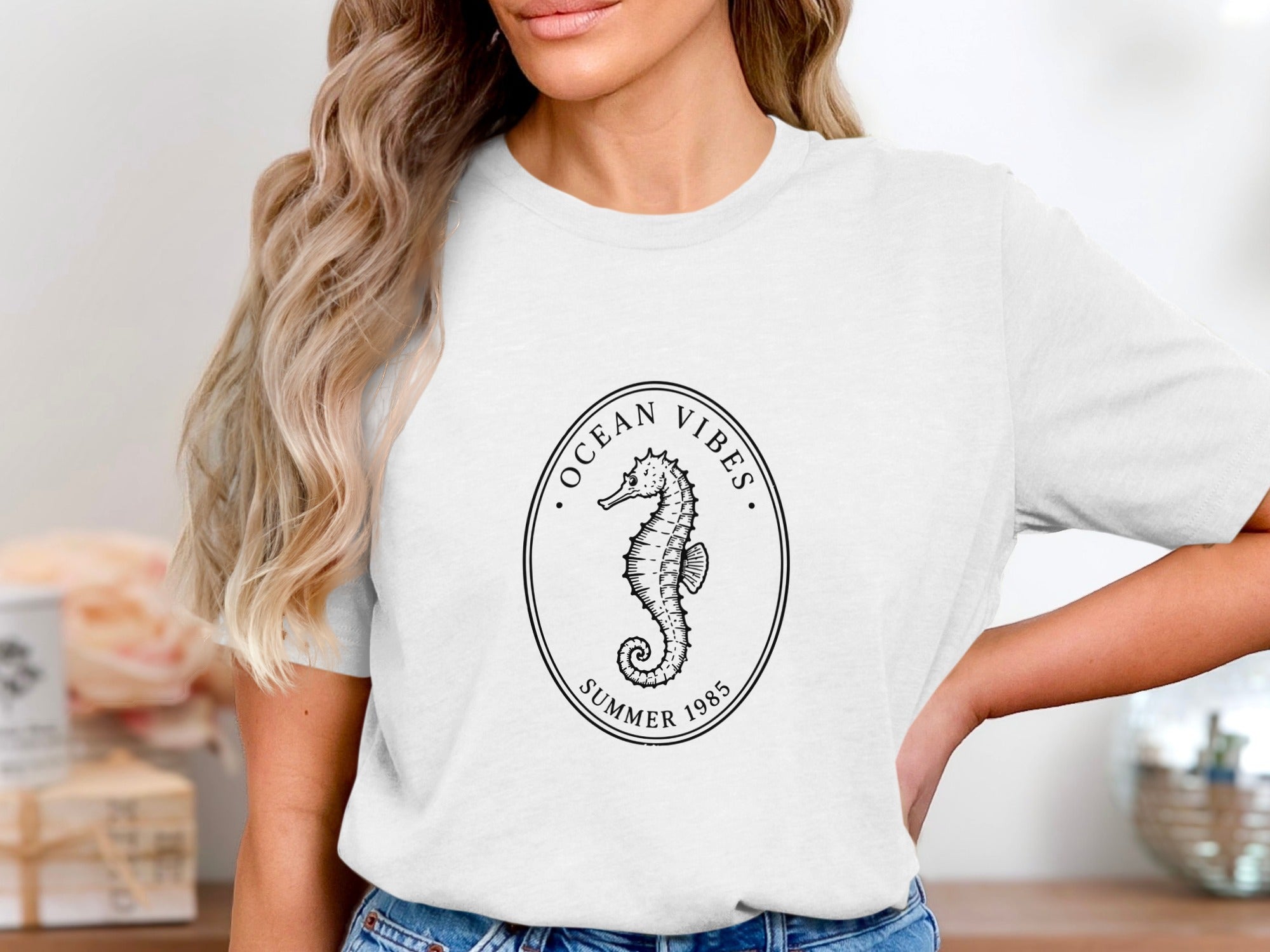 White t-shirt with oval seahorse graphic and text "Ocean Vibes Summer 1985".