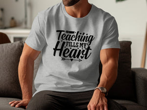 Grey t-shirt with black text "Teaching Fills My Heart" and pencil graphic.