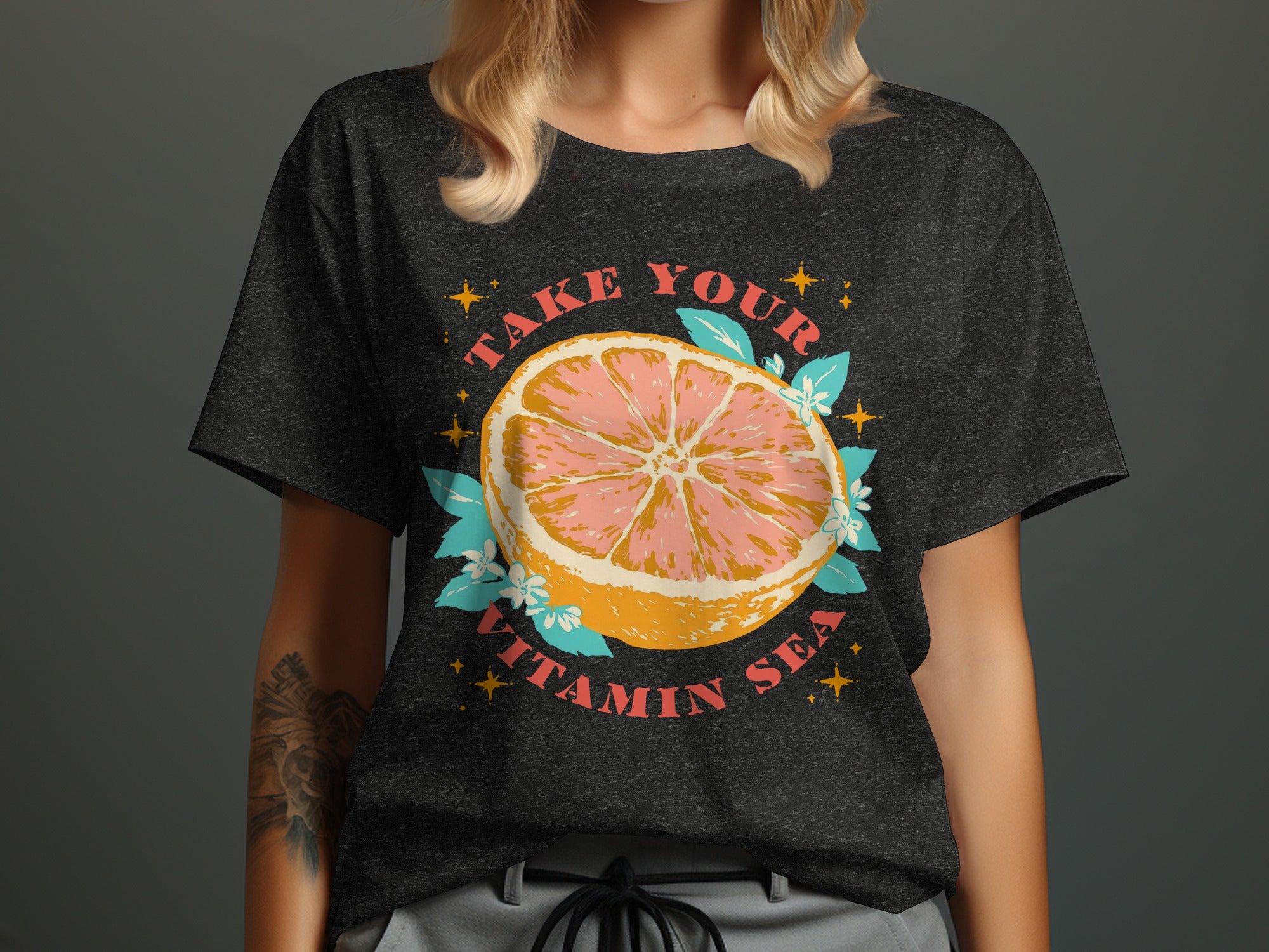 Dark t-shirt with a pink grapefruit slice graphic and "TAKE YOUR VITAMIN SEA" text.