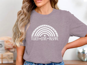 Grey t-shirt with a white rainbow graphic and text "TEACH LOVE INSPIRE".