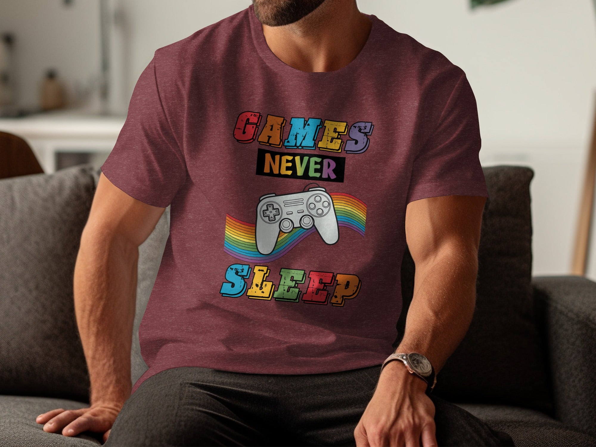Maroon t-shirt with text "GAMES NEVER SLEEP" and a colorful rainbow controller graphic.