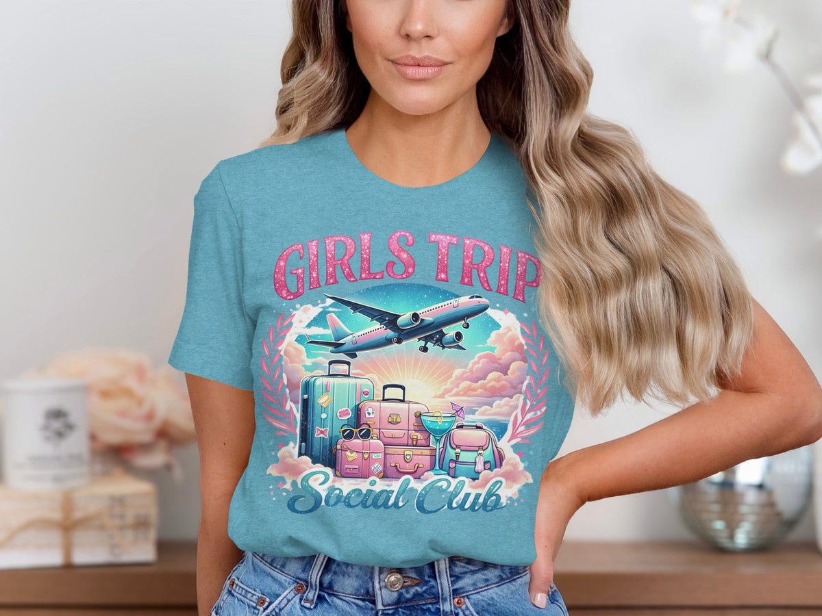 Teal t-shirt with "Girls Trip Social Club" graphic, airplane, luggage, and cocktail.