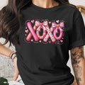 Black t-shirt with "XOXO" text design with hearts and bows.