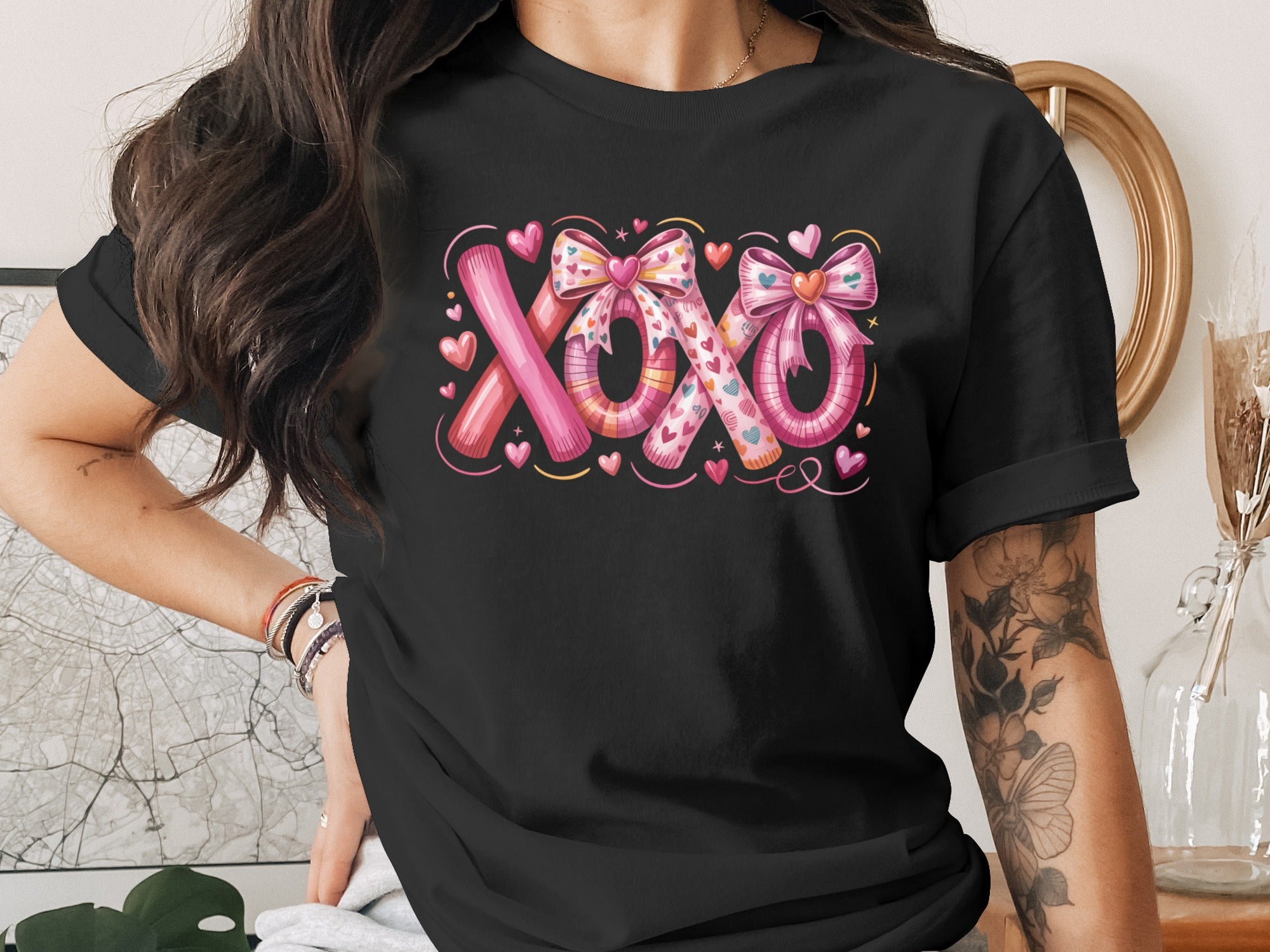 Black t-shirt with "XOXO" text design with hearts and bows.