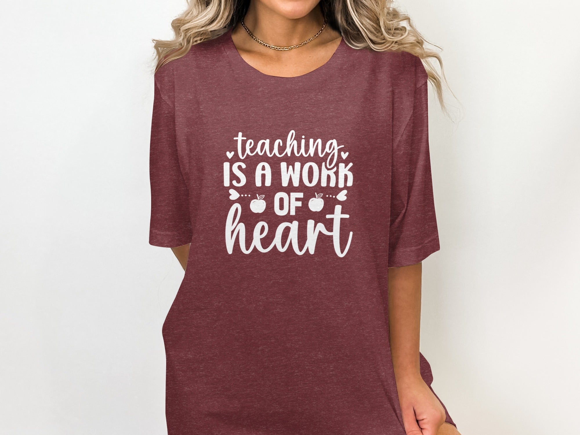 Maroon t-shirt with white text that reads "teaching is a work of heart".