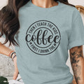 Light blue t-shirt with black circular text: "First I drink the coffee, then I teach the kids."
