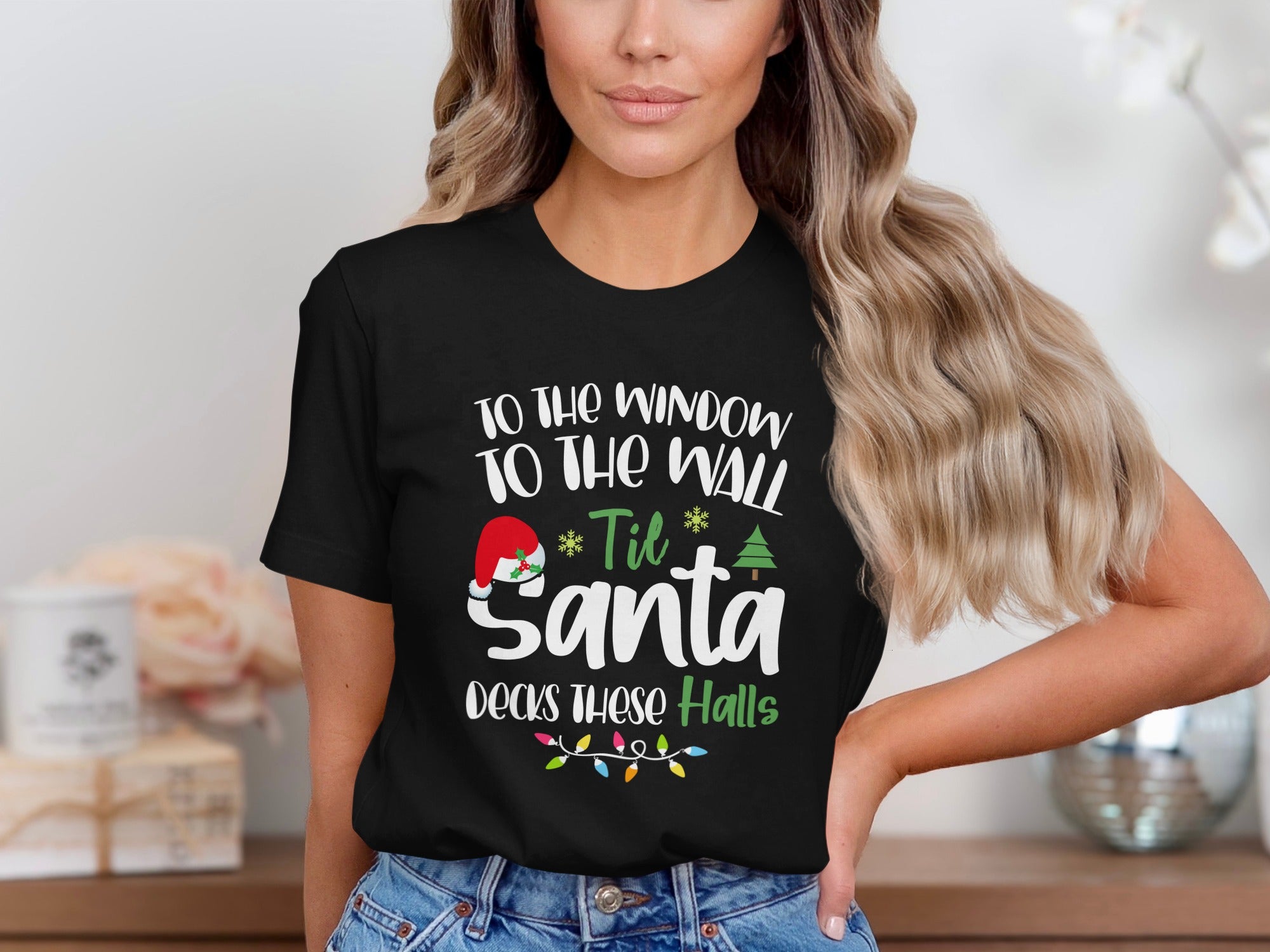 Black t-shirt with text "To the window to the wall 'til Santa decks these halls."