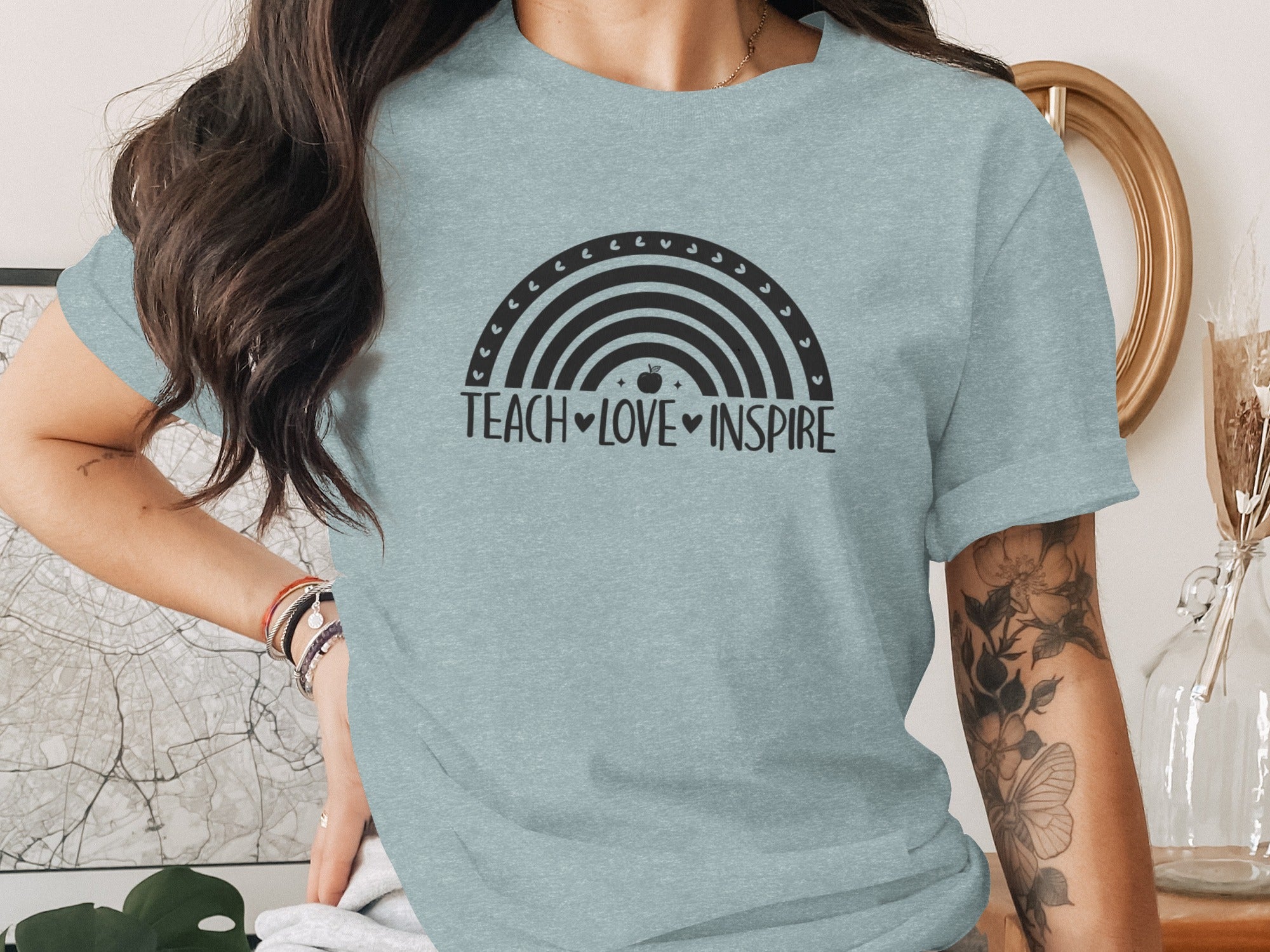 Light blue t-shirt with black rainbow graphic and "TEACH LOVE INSPIRE" text.
