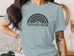 Light blue t-shirt with black rainbow graphic and "TEACH LOVE INSPIRE" text.