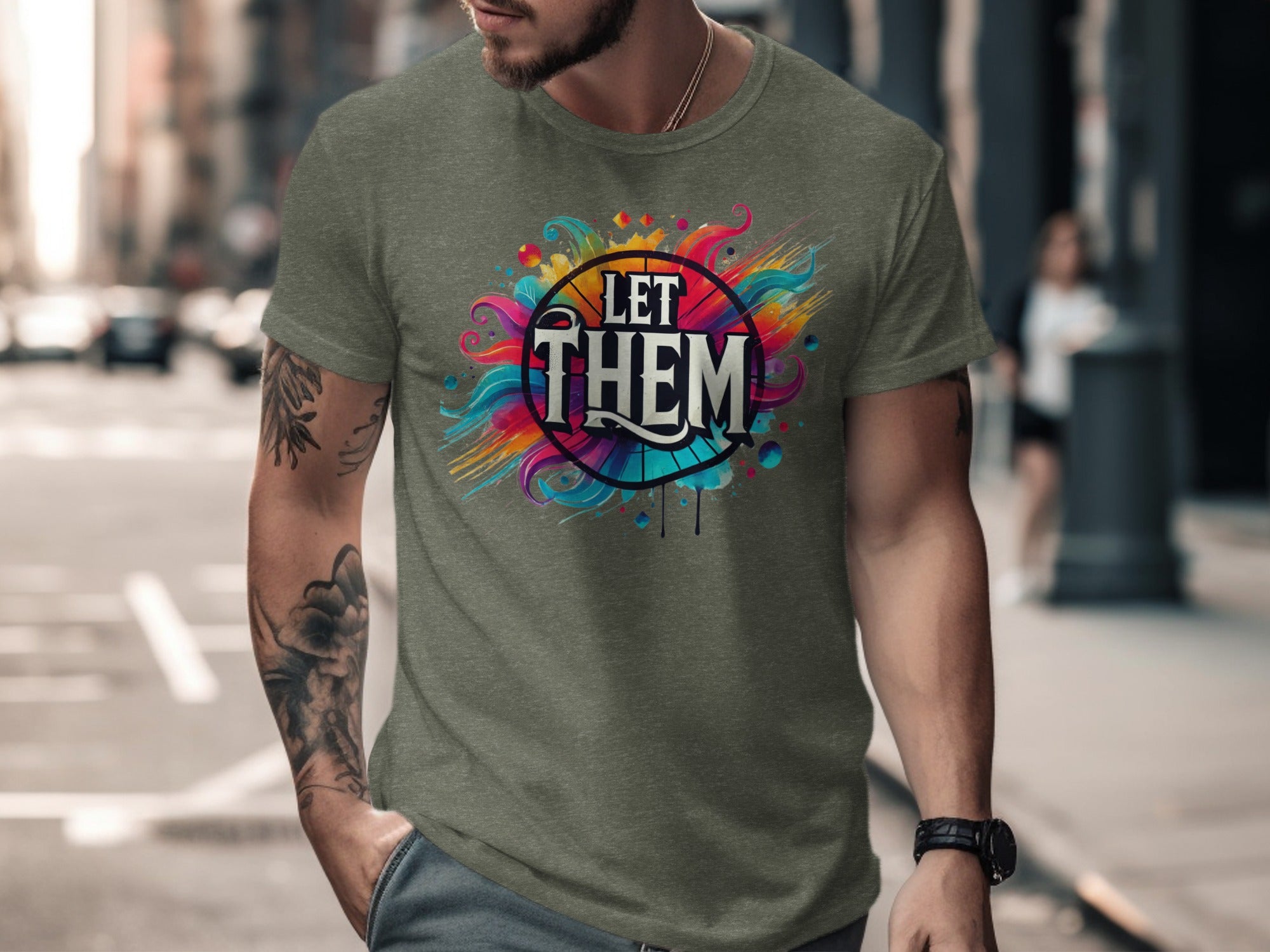 Green t-shirt with "LET THEM" text within a colorful, abstract design.