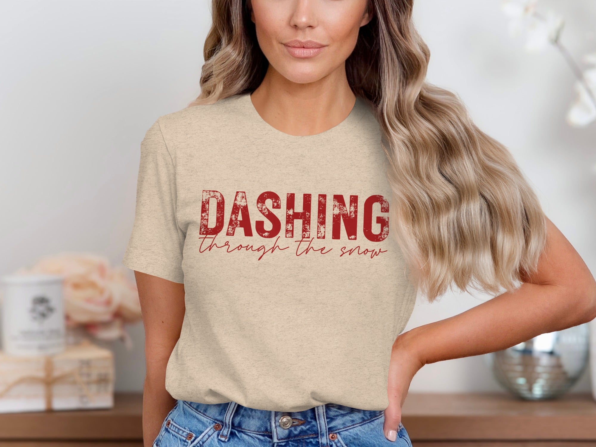 Light tan t-shirt with distressed red text that reads "DASHING through the snow".