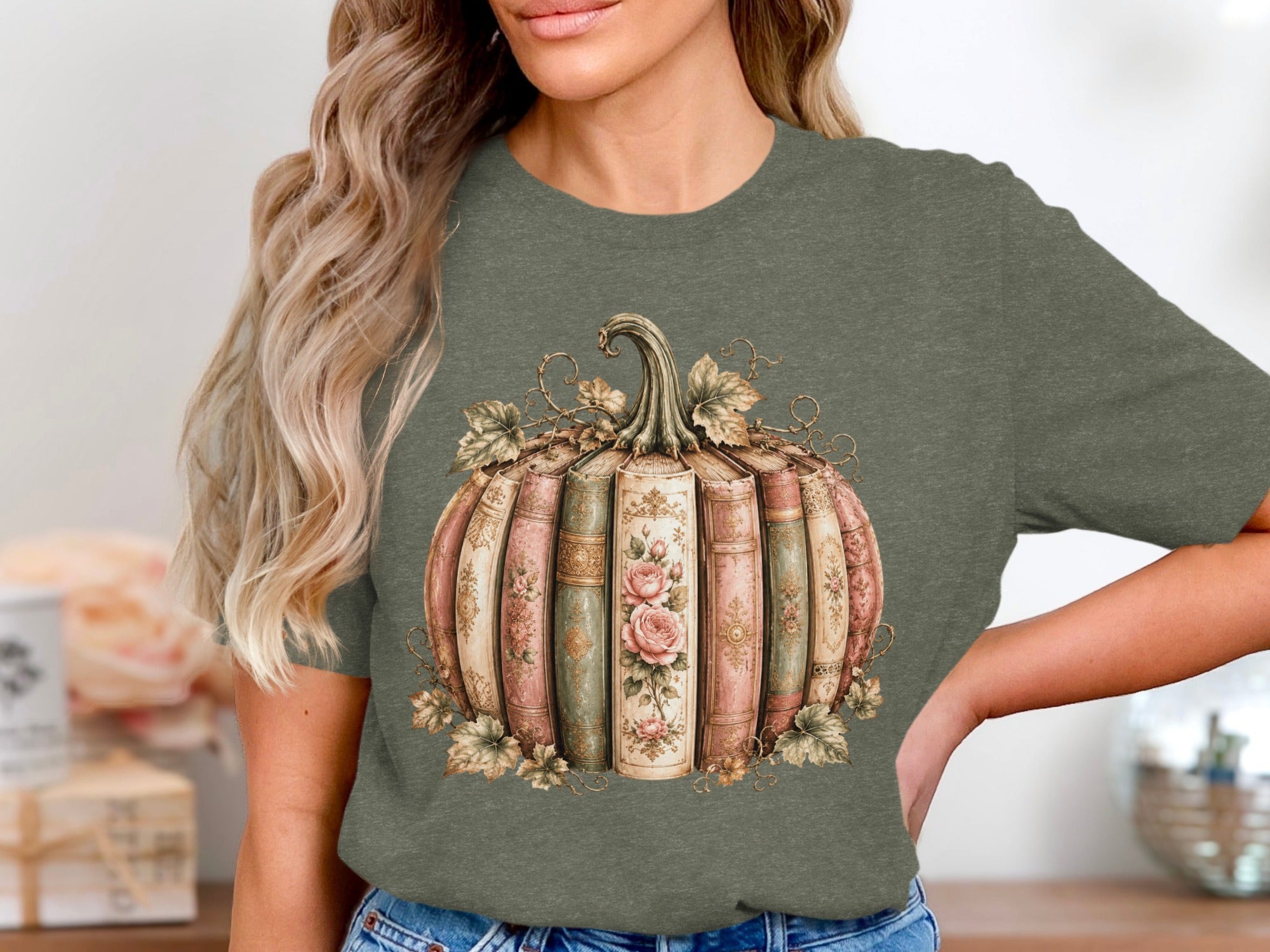 Green t-shirt featuring a pumpkin design made of vintage books with floral accents.