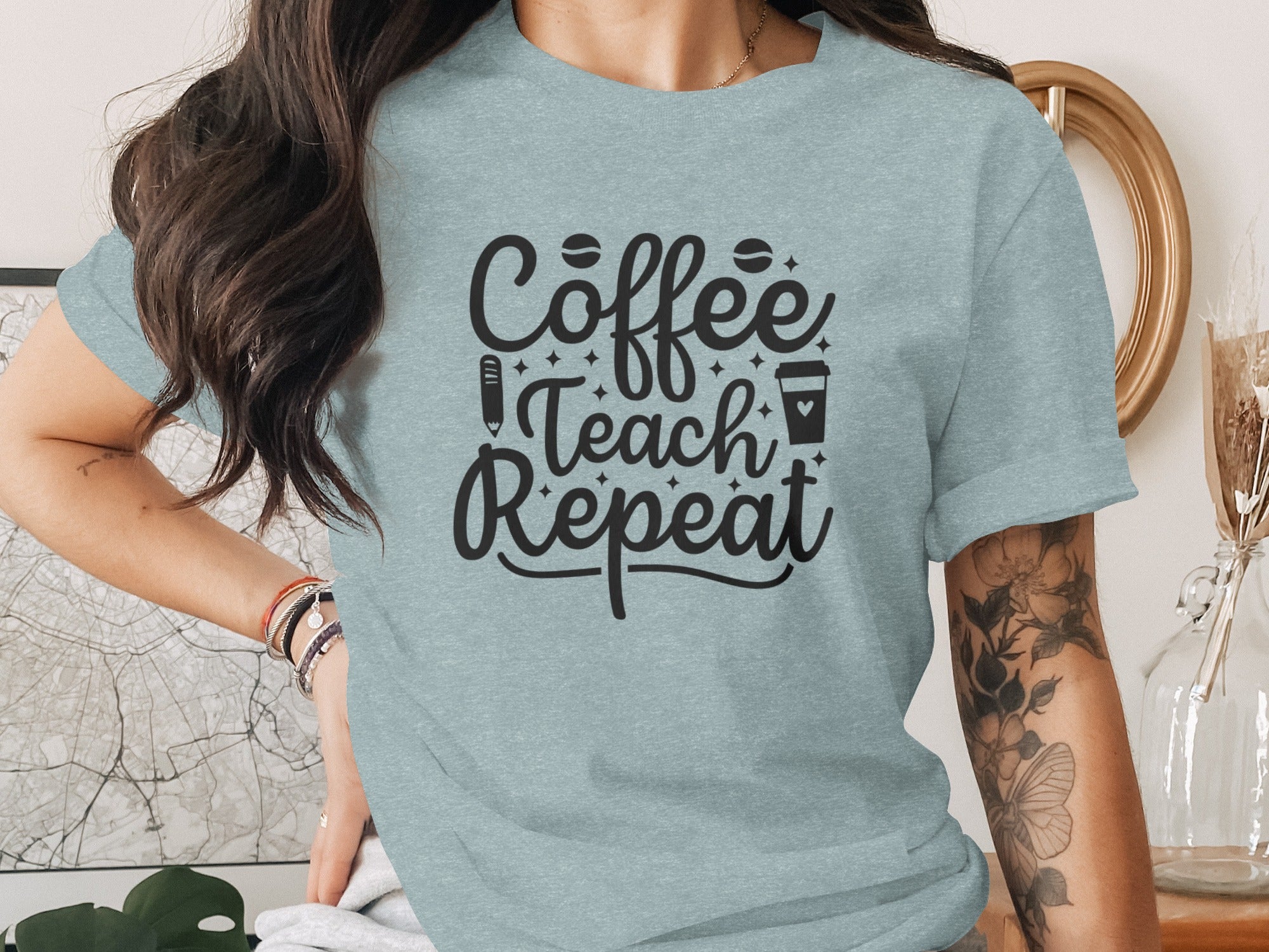 Light blue t-shirt with black text reading "Coffee Teach Repeat" and icons.