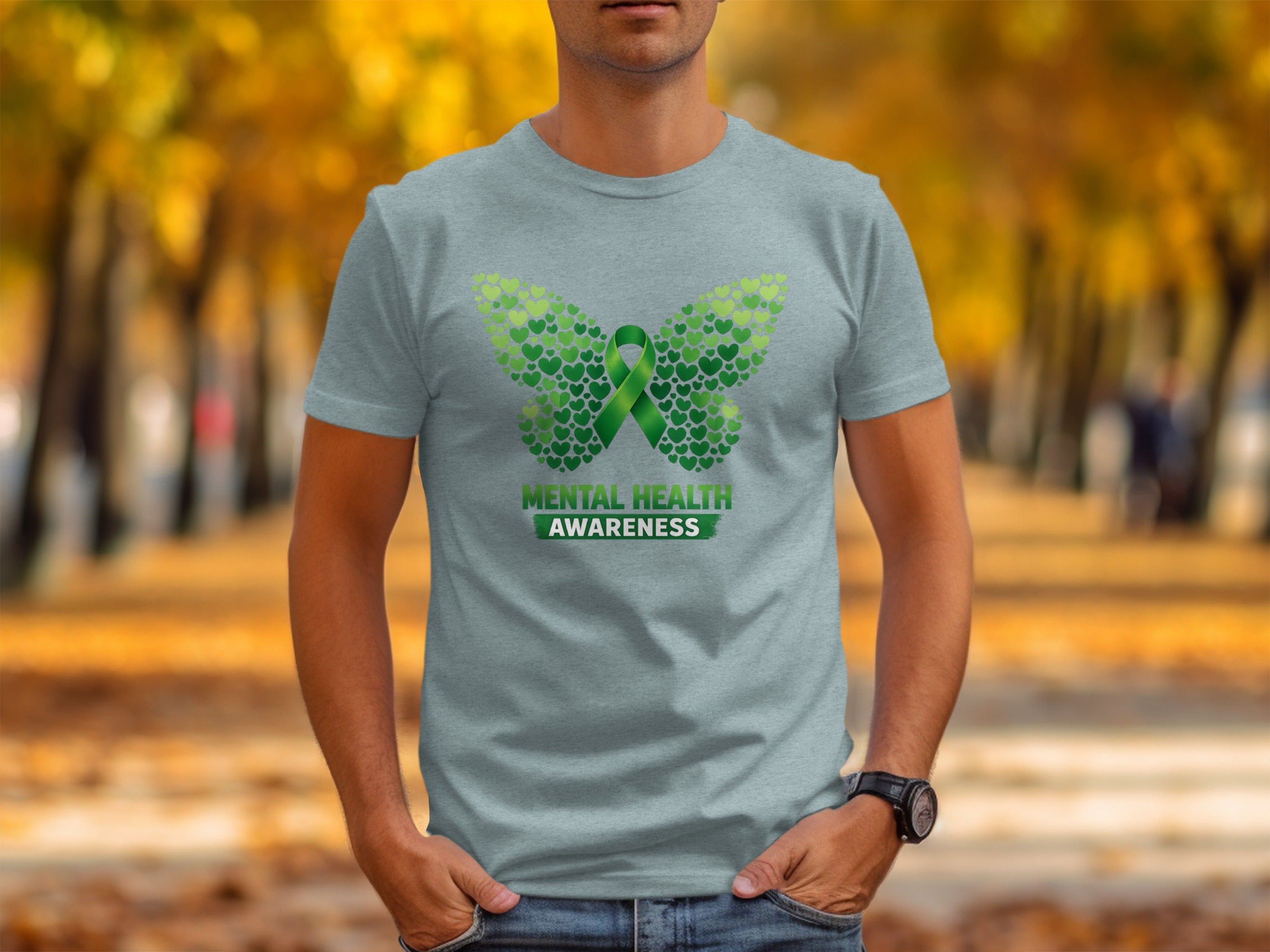 Light blue t-shirt with a butterfly design made of green hearts and "Mental Health Awareness" text.