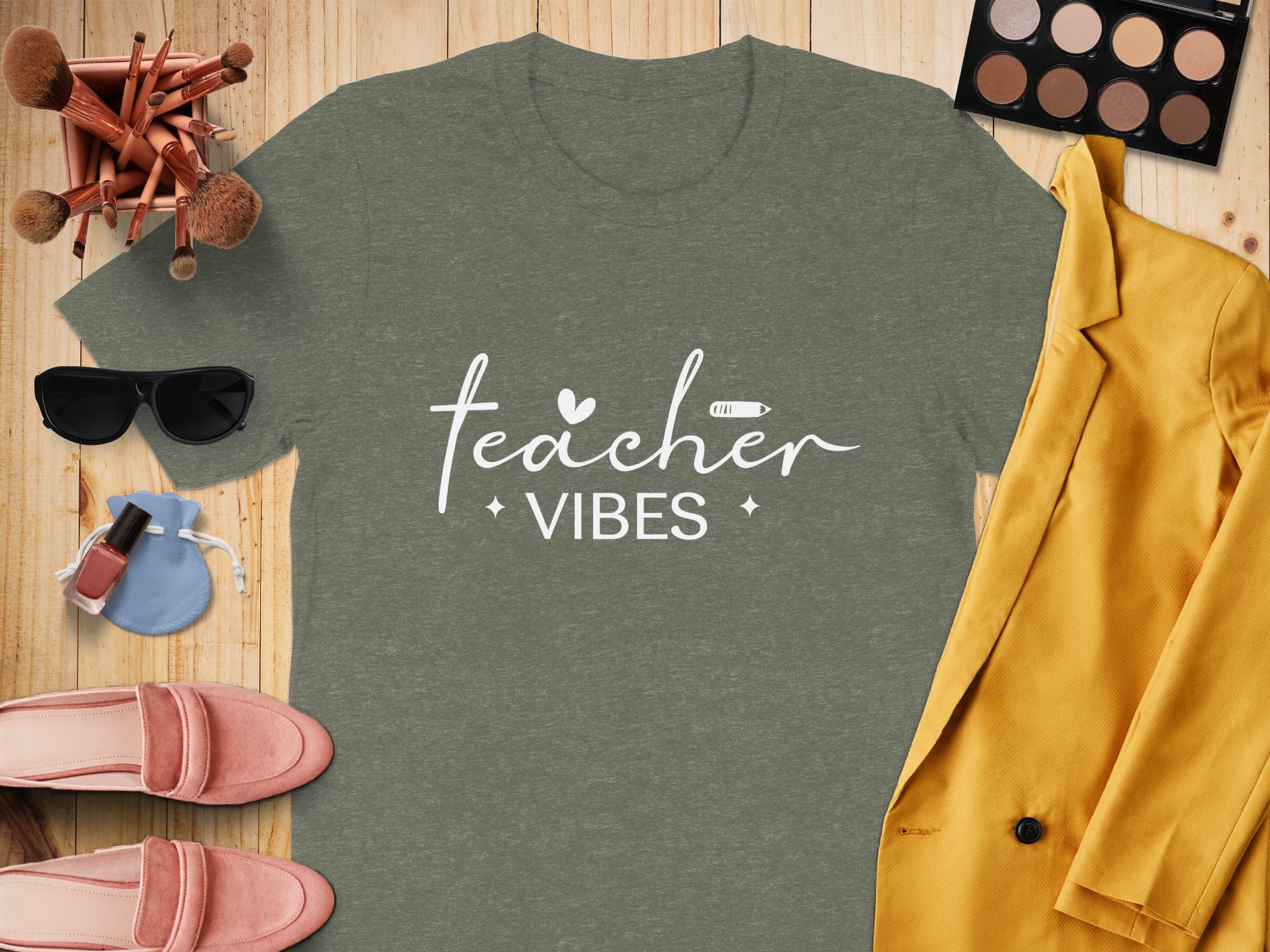 Olive green t-shirt with "teacher vibes" text and associated graphic elements.