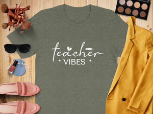 Olive green t-shirt with "teacher vibes" text and associated graphic elements.
