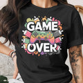 Black t-shirt with colorful "GAME OVER" text and controller graphic.
