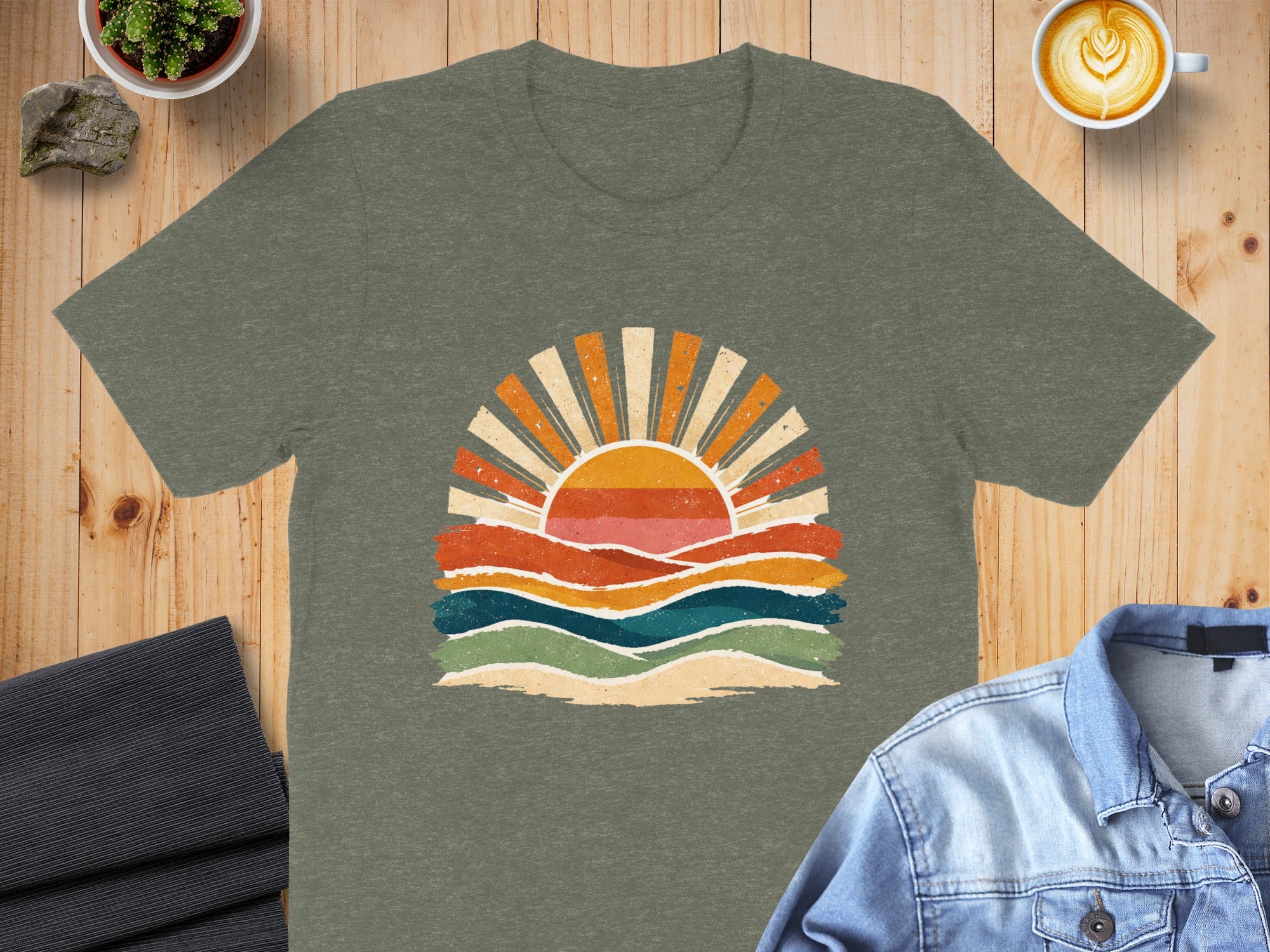 Olive green t-shirt with retro sunrise and wavy landscape graphic.