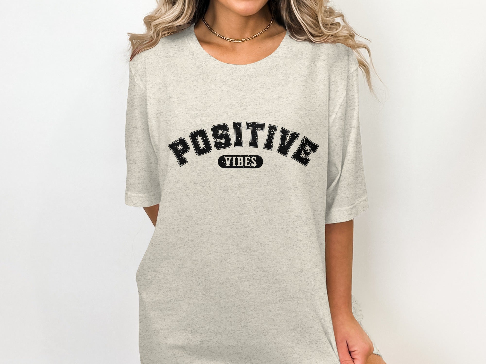 Light grey t-shirt with black text "POSITIVE VIBES" arched across the chest