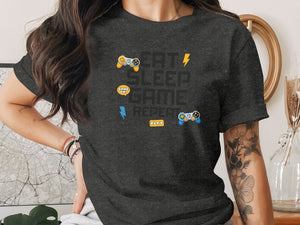 Dark grey t-shirt with "Eat Sleep Game Repeat" text and game controller graphics.
