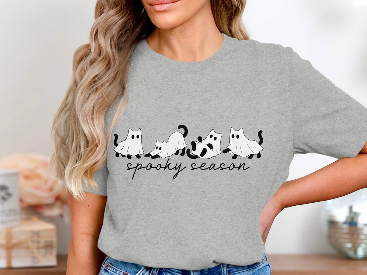 Grey t-shirt with cartoon cats in ghost costumes and "spooky season" text.