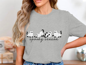 Grey t-shirt with cartoon cats in ghost costumes and "spooky season" text.