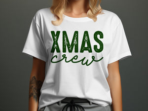 White t-shirt with green "XMAS crew" text and a partial arm tattoo.