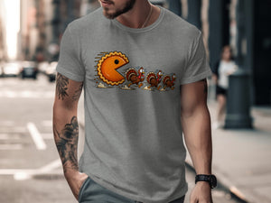 Pie character chasing cartoon turkeys on a grey t-shirt.