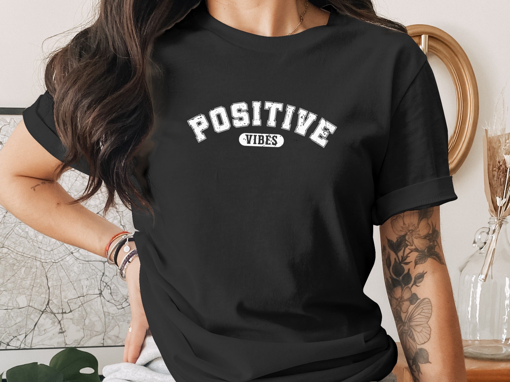 Black t-shirt with white "POSITIVE VIBES" text in arched collegiate font.