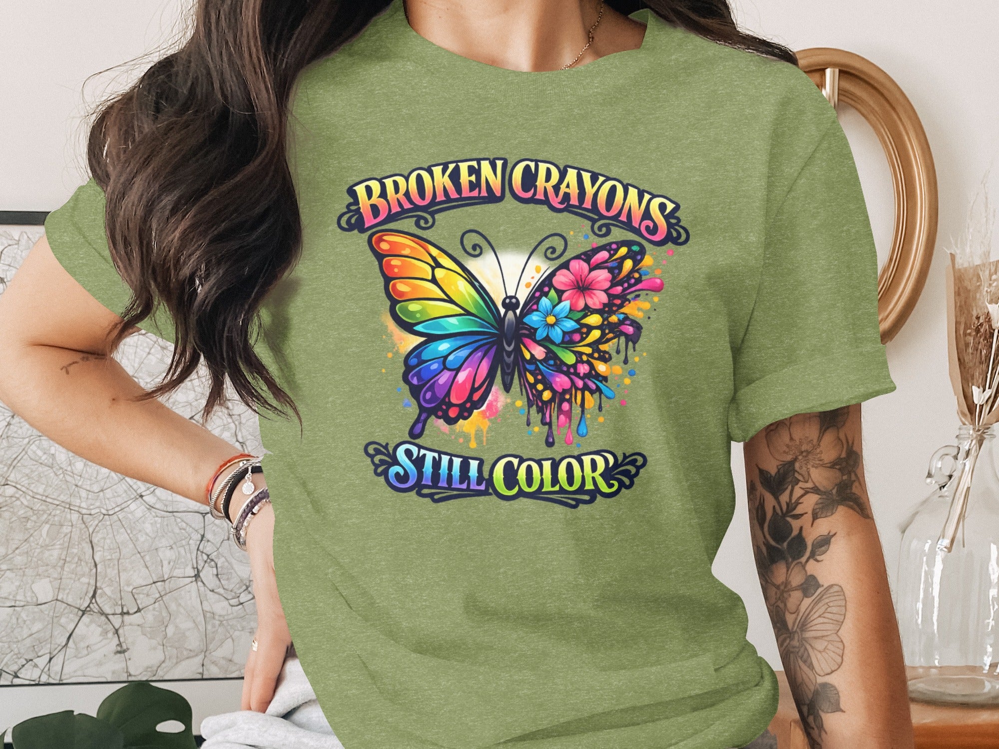 Green t-shirt with a butterfly design and text "BROKEN CRAYONS STILL COLOR."