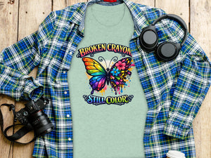 Light green t-shirt with rainbow butterfly and text "Broken Crayon Still Color."