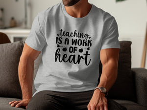 Grey t-shirt with black text "Teaching is a work of heart" and apples.