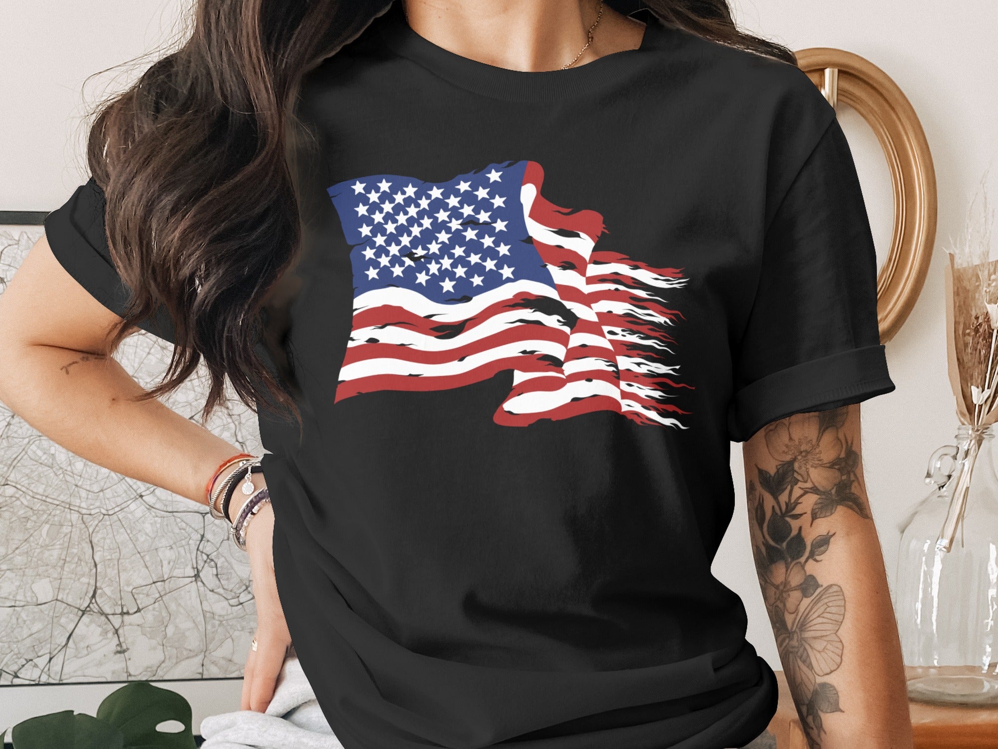 Black t-shirt with a distressed American flag graphic and floral arm tattoo.