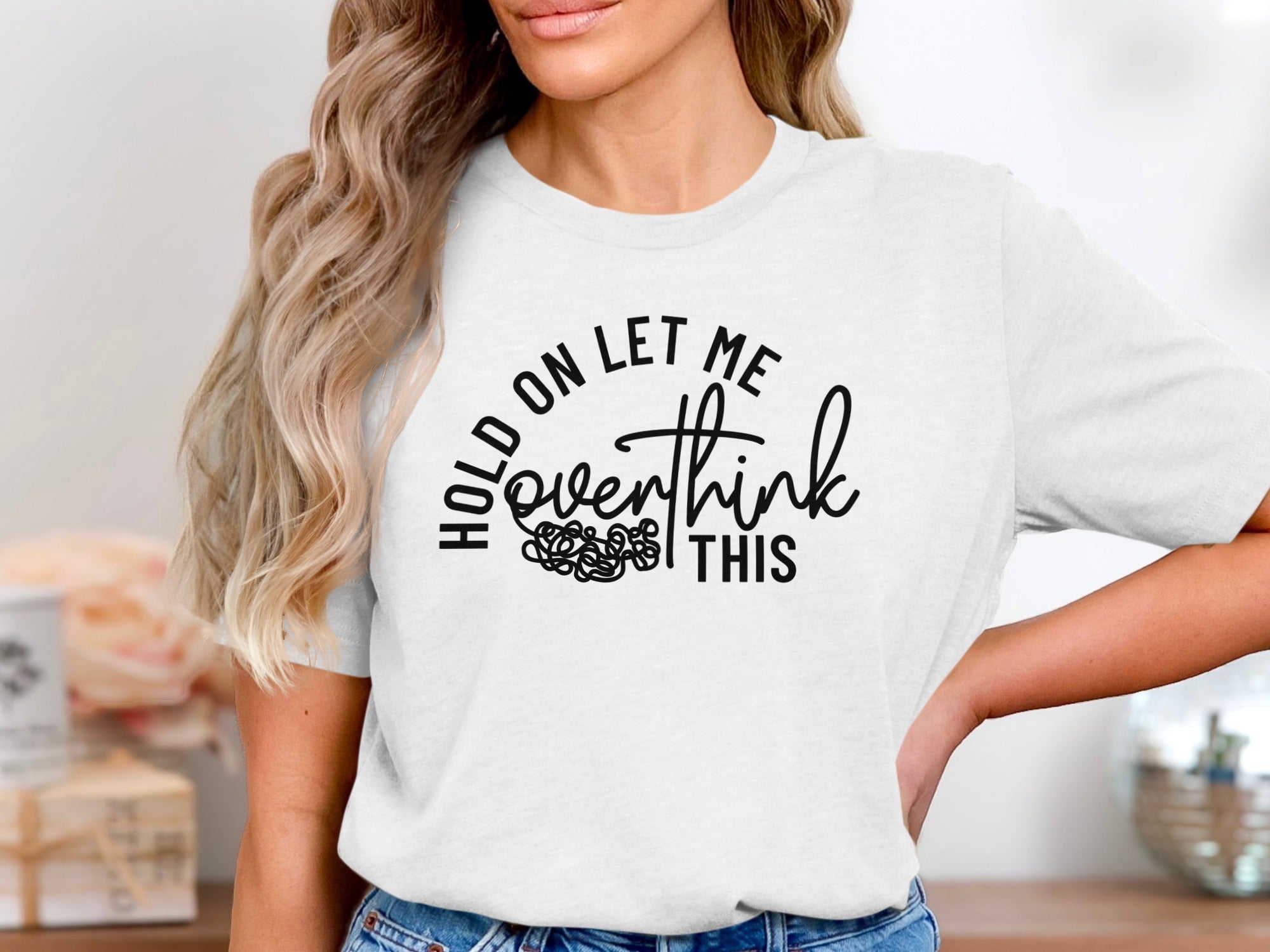 White t-shirt with black text reading "HOLD ON LET ME overthink THIS"