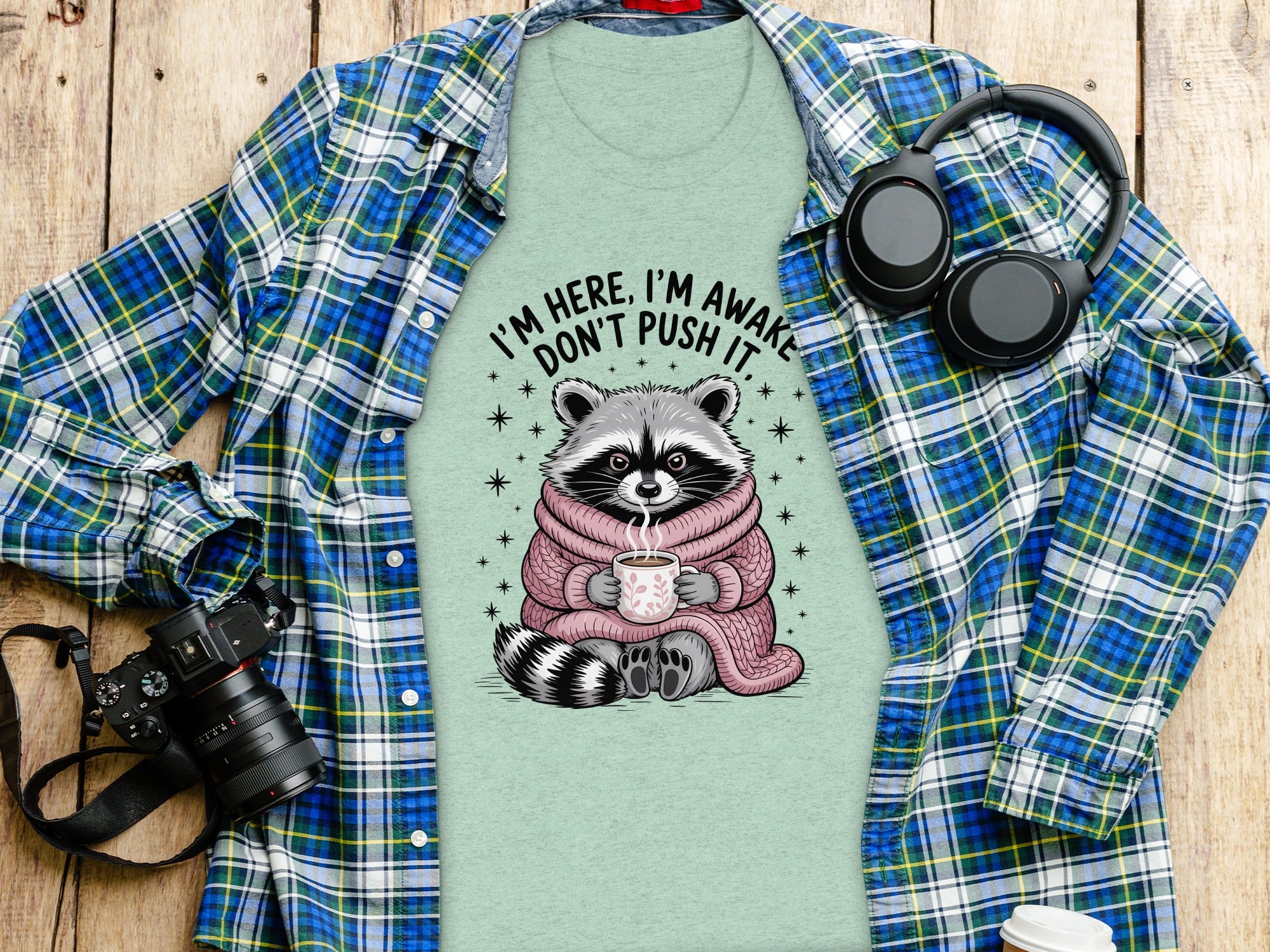 T-shirt with a raccoon holding a cup, text "I'm here, I'm awake, don't push it."