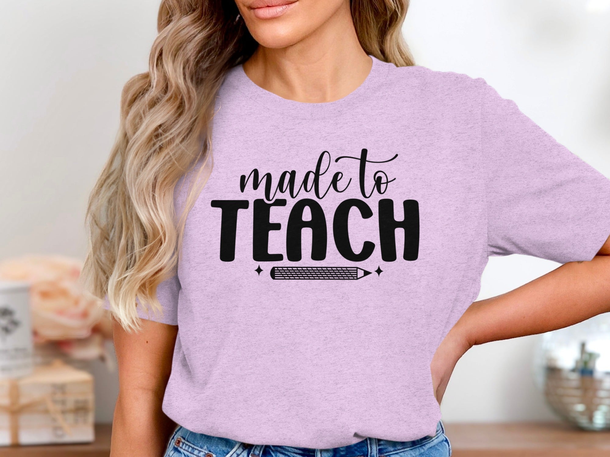 Lilac t-shirt with black text "made to TEACH" and a pencil graphic.