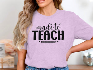 Lilac t-shirt with black text "made to TEACH" and a pencil graphic.