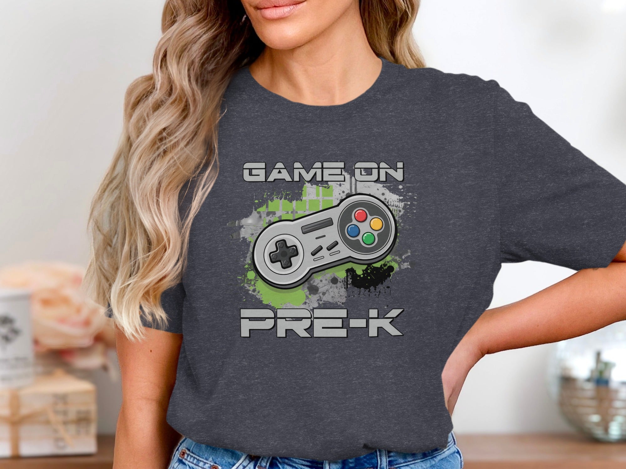 Dark t-shirt graphic with "GAME ON PRE-K" text and a retro video game controller.
