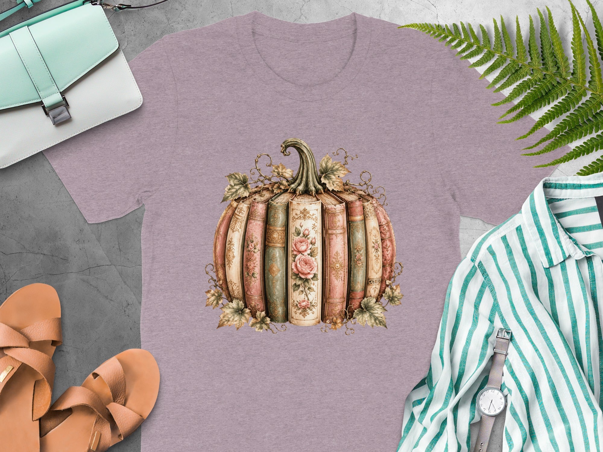 Lilac t-shirt with an illustrated pumpkin made of vintage books with floral details.