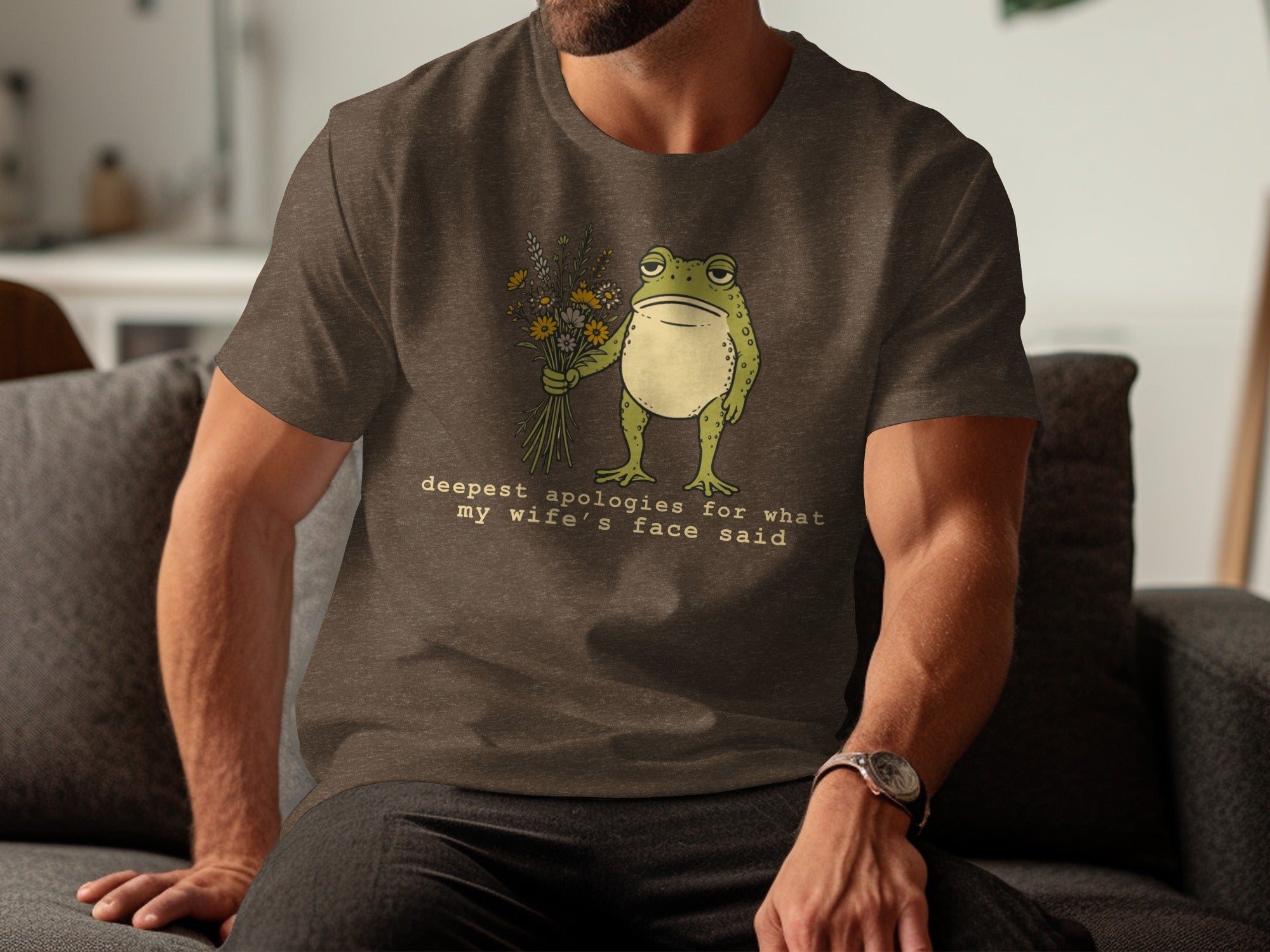 T-shirt graphic of a frog holding flowers with text "deepest apologies for what my wife's face said"