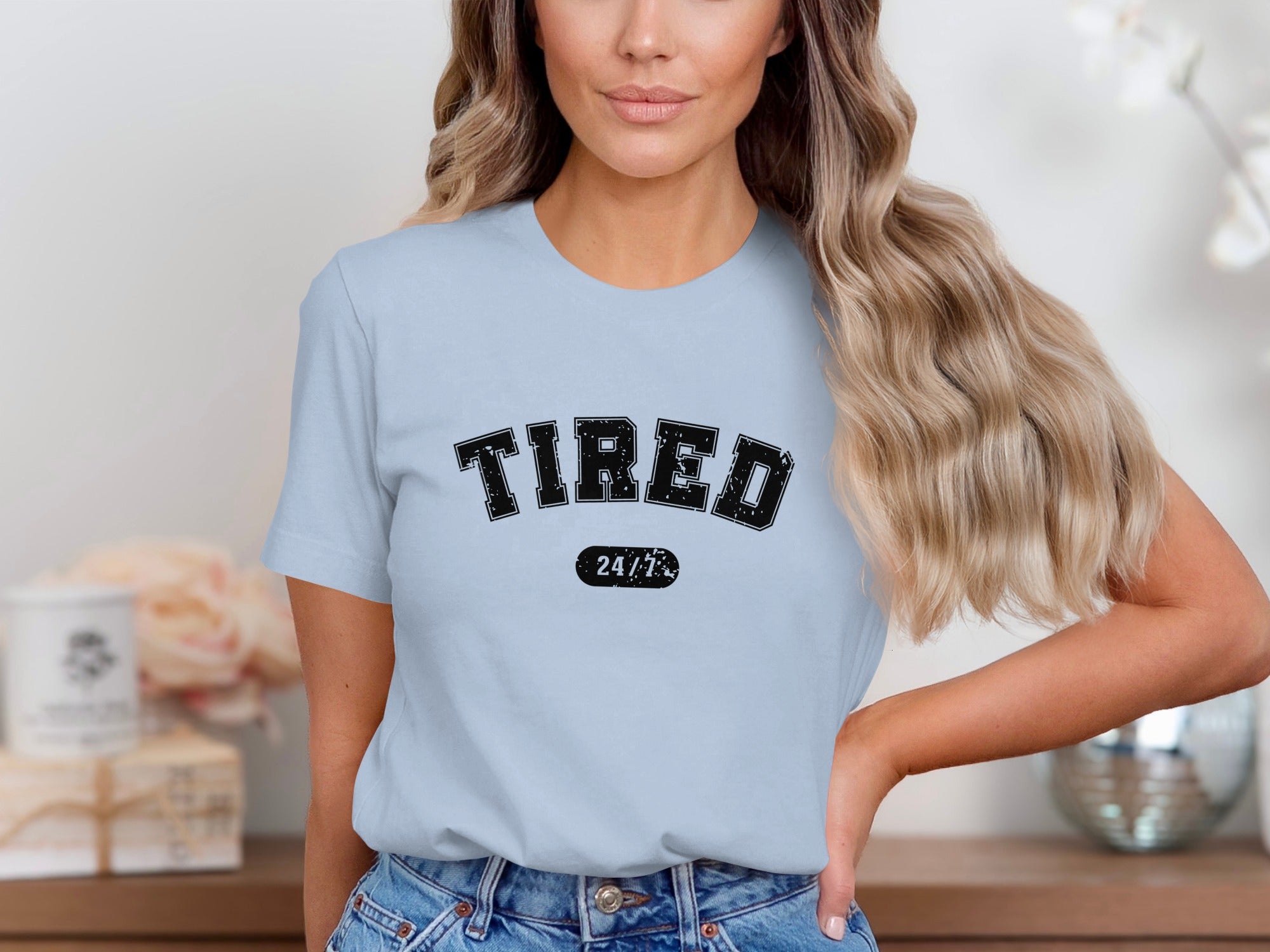 Light blue t-shirt with black text that reads "TIRED 24/7" across the chest.