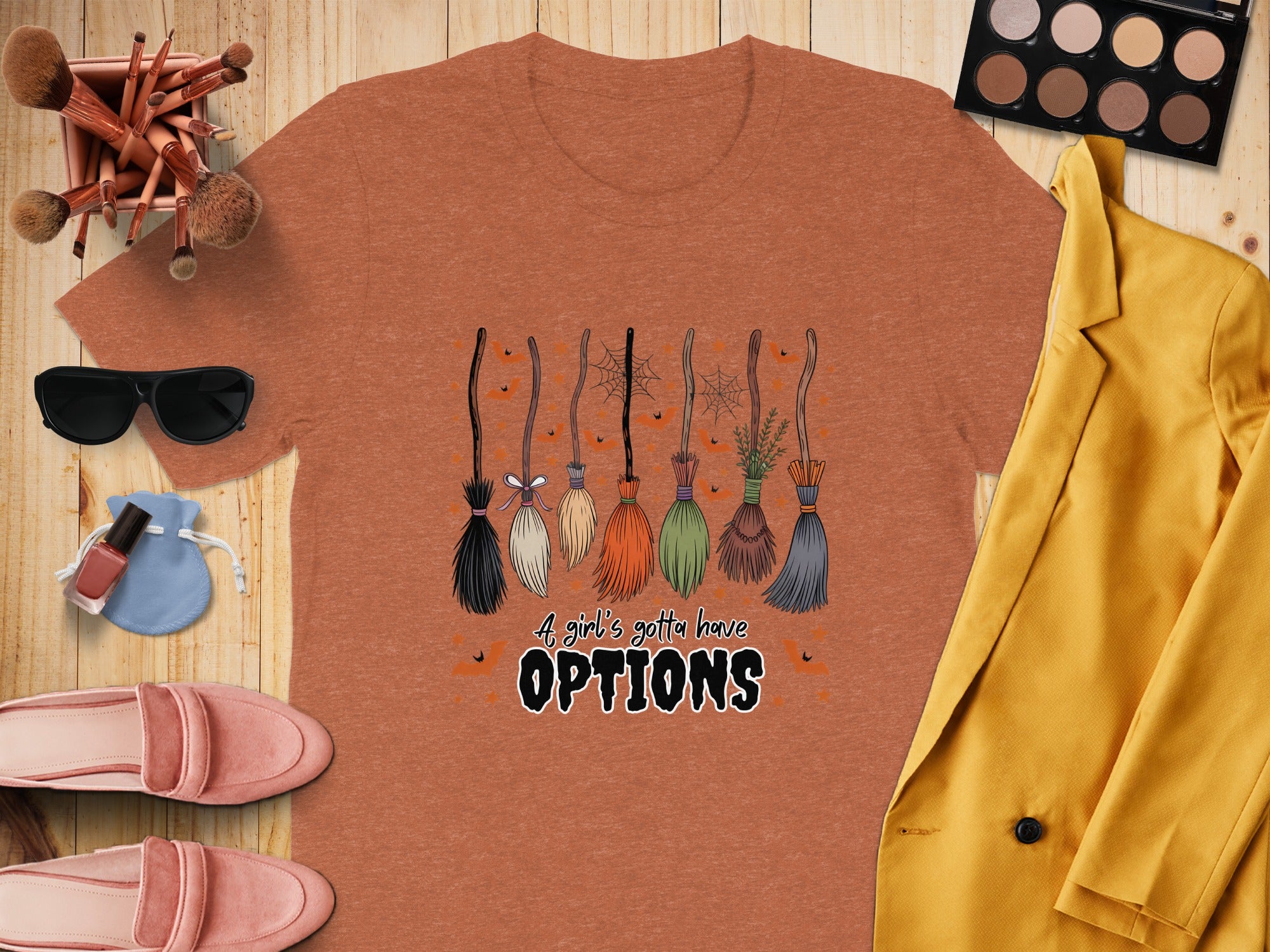 Orange t-shirt with cartoon brooms and "A girl's gotta have OPTIONS" text.