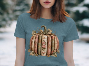 Pumpkin made of vintage books with roses and autumn leaves graphic on teal t-shirt.